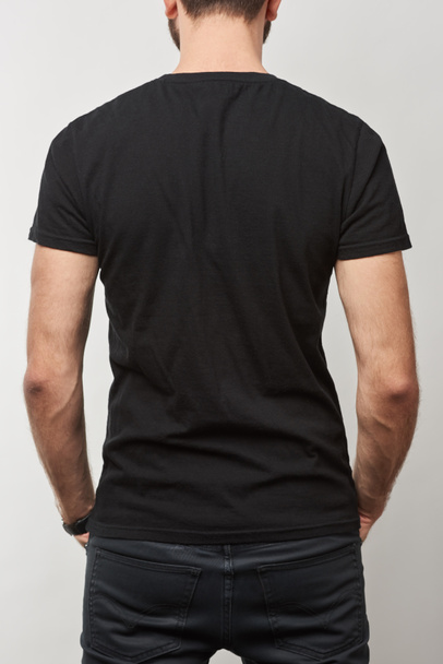 vista trasera del hombre en camiseta de algodón negro con espacio de copia aislado en gris
 - Foto, imagen