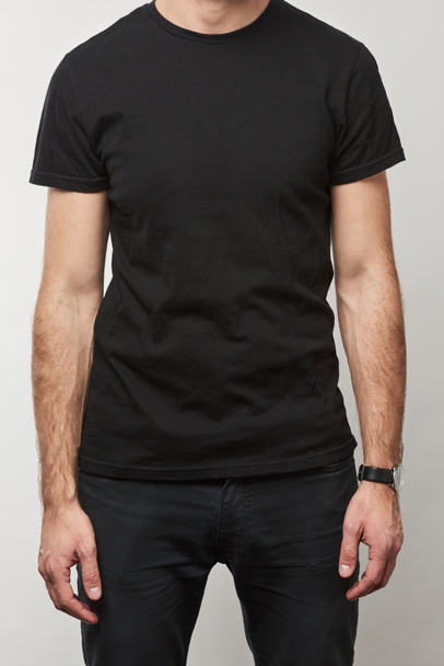 partial view of man in black t-shirt with copy space isolated on grey  - Foto, imagen