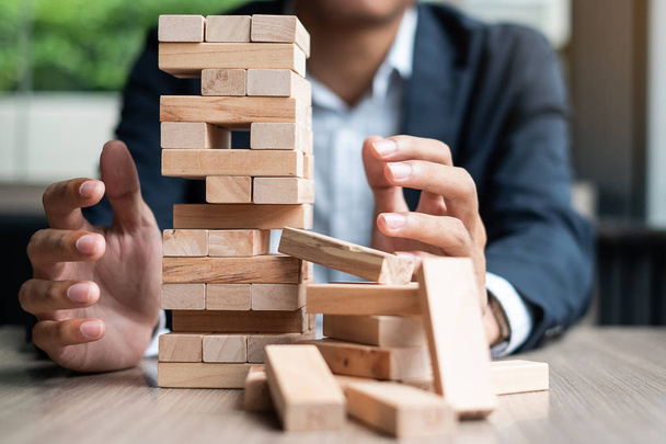 Businessman hand cover wooden block on the tower. Business planning, Risk Management, Solution and strategy Concepts - Фото, зображення