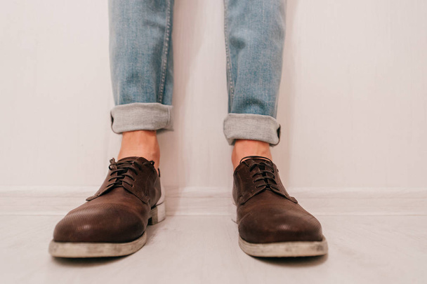 partial view of man in brown shoes standing on light background - Foto, afbeelding