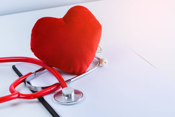 Red heart and stethoscope with empty clipboard on white table with copy space - Foto, Imagem