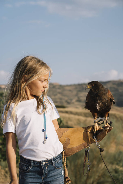 Petite fille avec l'oiseau rapace dans sa main
 - Photo, image