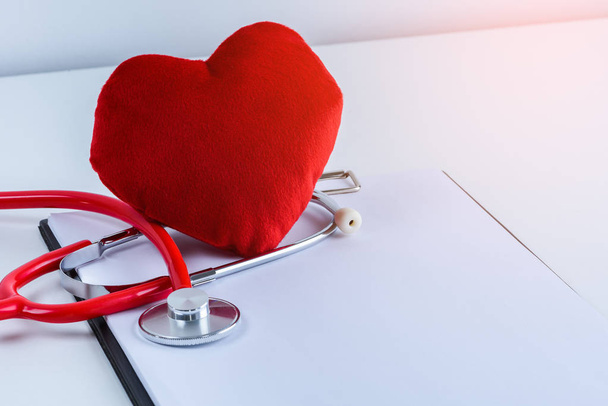Red heart and stethoscope with empty clipboard on white table with copy space - Foto, Bild