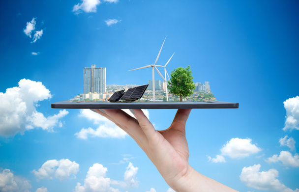 Ekologiczny system energii słonecznej w mieście na dłoni trzymając tabletkę - Zdjęcie, obraz