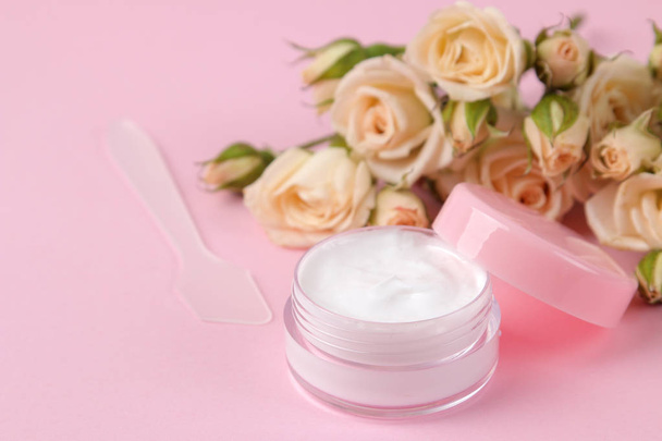 cosmetics for face and body in pink bottles with fresh roses on a delicate pink background. cream and lotion. spa. - Foto, afbeelding