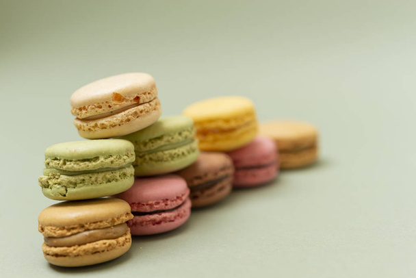Vintage pastelově barevné francouzské makronky nebo macarons na zeleném pozadí - Fotografie, Obrázek