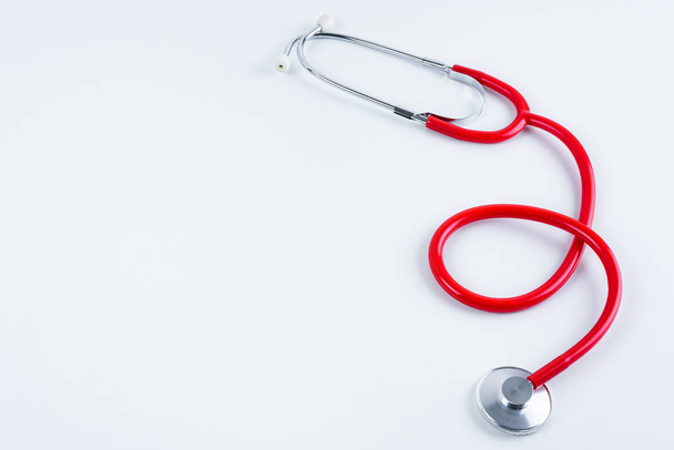 Red heart and stethoscope on white table with copy space - 写真・画像