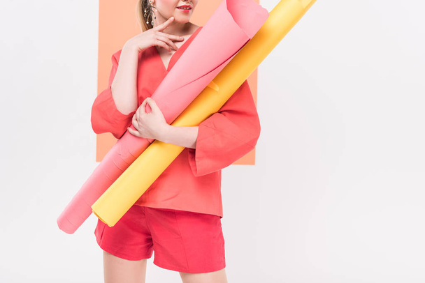 cropped view of girl holding paper rolls and posing with copy space and living coral on background - Foto, Imagen