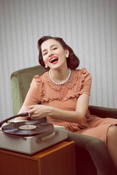 Young woman listening to music from a turntable - Foto, Imagem