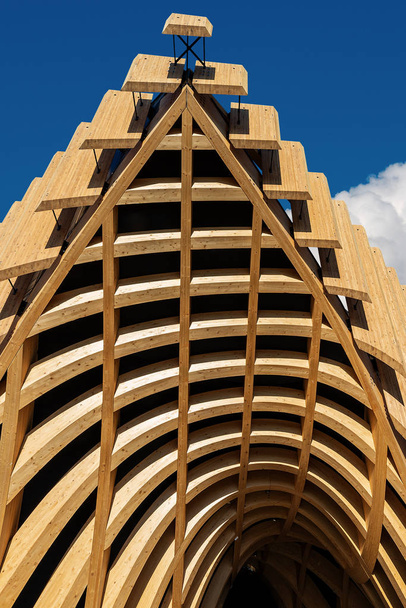 Nahaufnahme einer modernen Architektur aus Brettschichtholz auf blauem Himmel mit Wolken - Foto, Bild