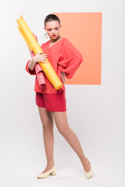 beautiful fashionable girl holding paper rolls and posing with living coral on background - Foto, Imagem