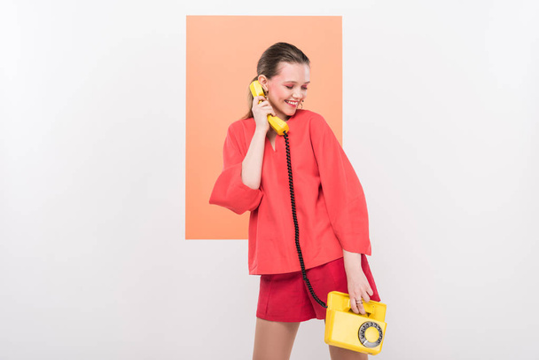 stylish girl holding retro telephone and posing with living coral on background - Foto, Imagen