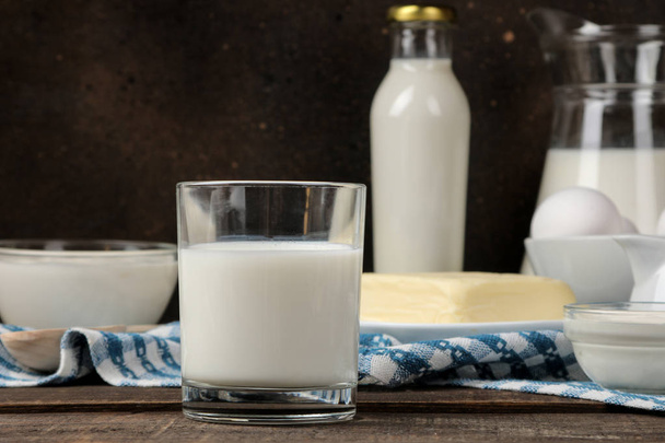 mléčné výrobky. mléko, zakysaná smetana, sýr, máslo a tvaroh na hnědý dřevěný stůl - Fotografie, Obrázek