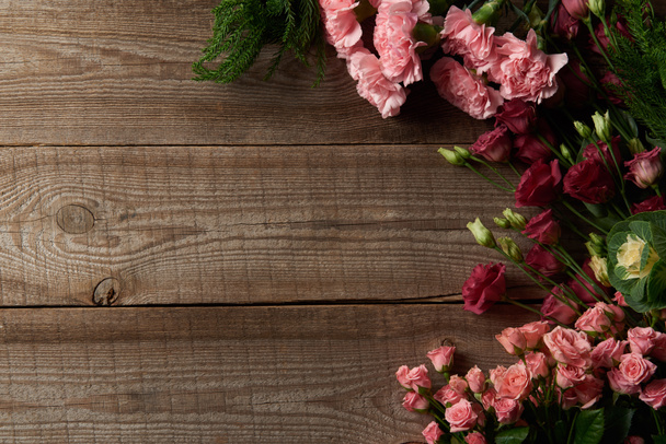 το top view από όμορφα κόκκινα και ροζ λουλούδια σε ξύλινη επιφάνεια - Φωτογραφία, εικόνα