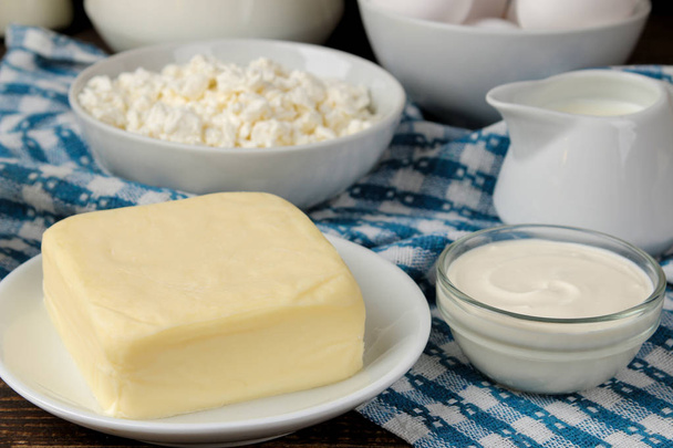 milk products. milk, sour cream, cheese, butter and cottage cheese on a brown wooden table - Photo, Image