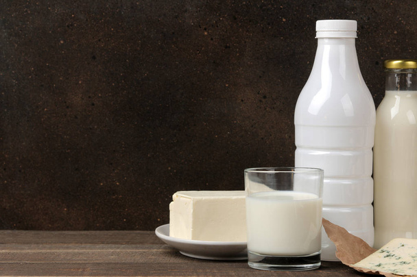 Milchprodukte. Milch, saure Sahne, Käse, Butter und Quark auf einem braunen Holztisch. Raum für Text - Foto, Bild