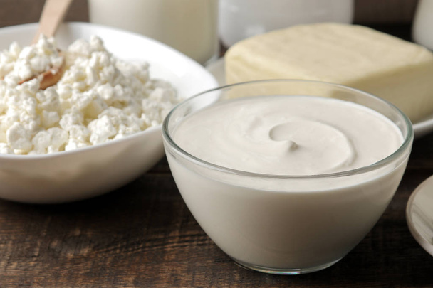 produtos lácteos. leite, nata azeda, queijo, manteiga e queijo cottage em uma mesa de madeira marrom
 - Foto, Imagem
