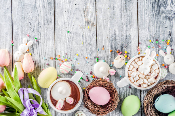 Pasqua divertente bambini cibo e bevande concetto, dolce cioccolata calda con conigli marshmallow coniglietto e uova di Pasqua, sfondo in legno copia spazio vista dall'alto
 - Foto, immagini