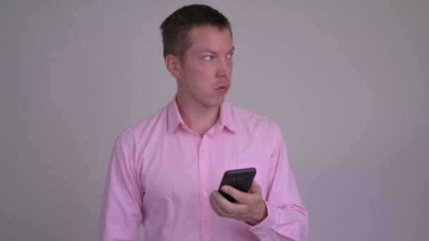 Young stressed businessman using phone and getting bad news - Filmagem, Vídeo