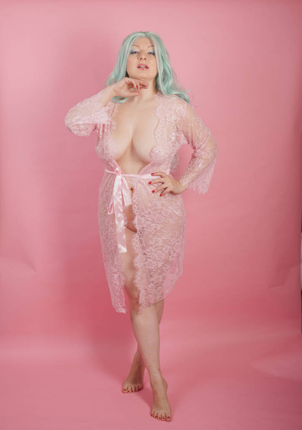 curvy chubby sexy adult woman posing naked in transparent cute dresses alone on pink studio background - Photo, Image