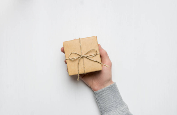 Ανδρικό χέρι κρατούν ένα κουτί δώρου. απομονωθεί σε λευκό φόντο - Φωτογραφία, εικόνα