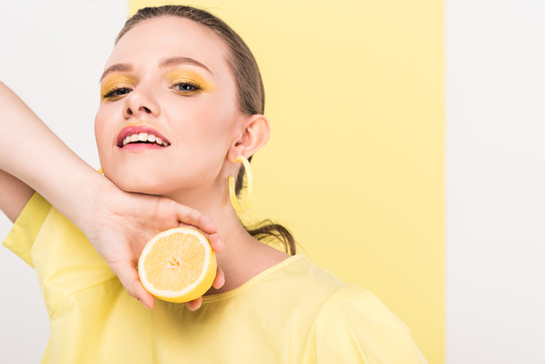 beautiful stylish girl holding lemon and posing with copy space and limelight on background - Foto, imagen