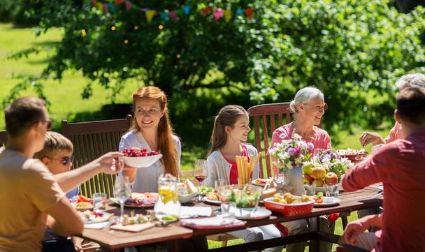 happy family having dinner or summer garden party - Foto, afbeelding