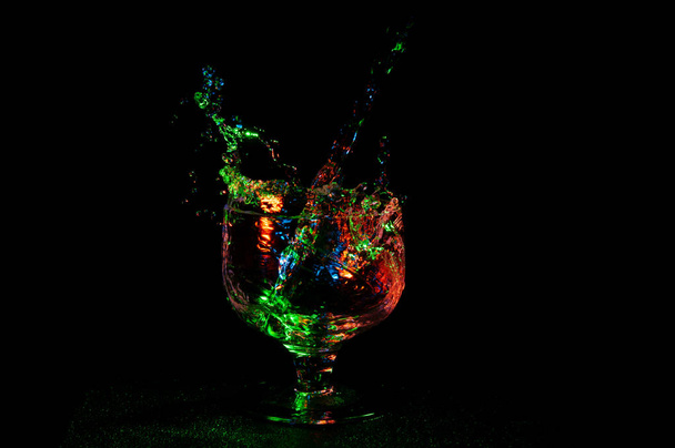 Grande éclaboussure colorée de liquide dans un verre de brandy
 - Photo, image
