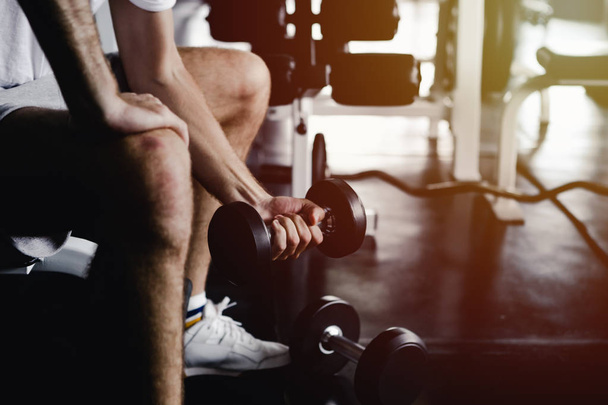 Los hombres de primer plano saludable celebración de ejercicios de mancuerna y la construcción de cuerpo en el gimnasio de fitness
 - Foto, imagen