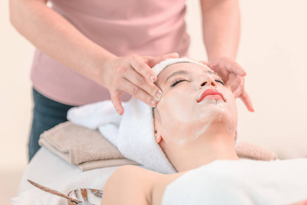 Krásná mladá žena používá kosmetické krémy na tváři relaxační masáž, koncept lázeňského obličeje - Fotografie, Obrázek