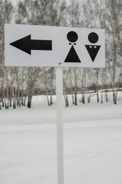 Een wijzer naar een openbaar toilet en het teken van een man en een vrouw. Hygiëne in het park, open verticaal frame - Foto, afbeelding