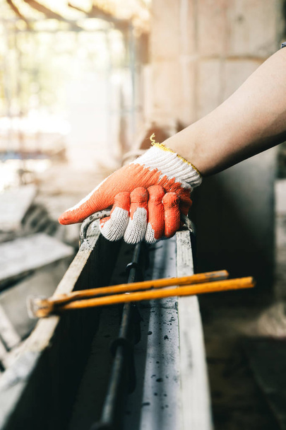 Fechar as mãos dos trabalhadores usando pinças ligar fio de aço para vergalhões antes de concreto é derramado sobre ele
. - Foto, Imagem