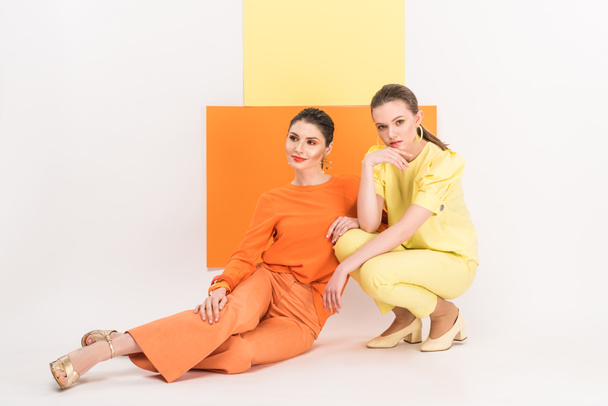 beautiful stylish girls sitting and posing with turmeric and limelight on background - Photo, Image