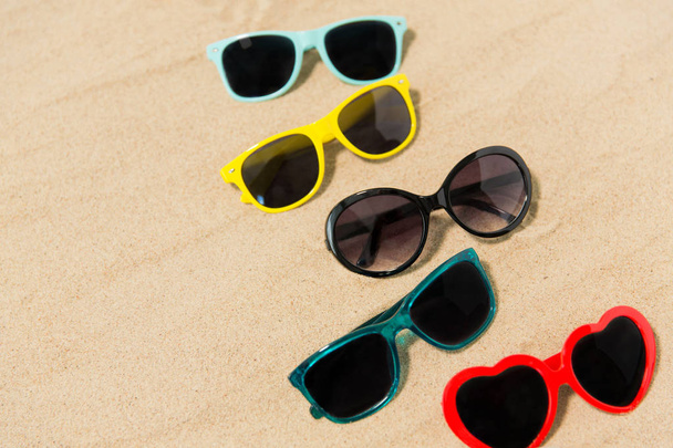 different sunglasses on beach sand - Zdjęcie, obraz