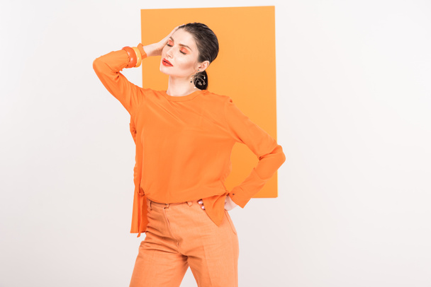 beautiful fashionable woman with eyes closed posing with turmeric on background - Foto, imagen