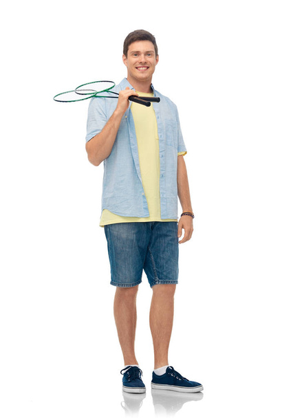 smiling young man with badminton rackets - Zdjęcie, obraz
