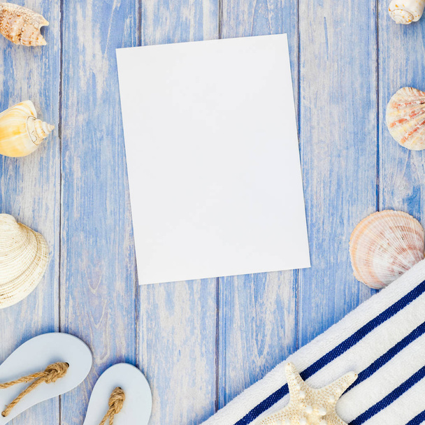 Square Creative flat lay concept summer travel vacations. Top view of towel flip flops seashells and starfish on pastel blue wooden planks background with copy space rustic style frame template text - 写真・画像