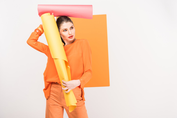 stylische junge Frau mit Papierrollen und posiert mit Kopierraum und Kurkuma auf dem Hintergrund - Foto, Bild