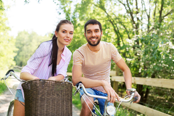happy couple with bicycles at summer park - Photo, Image