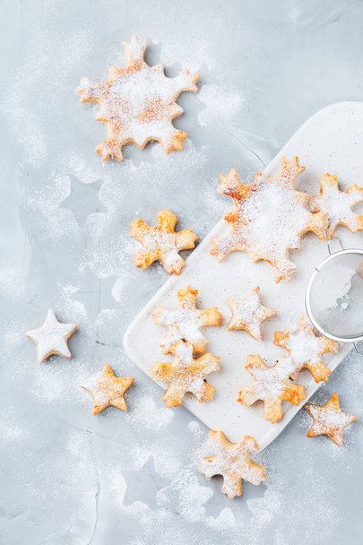 Cibo e bevande, concetto di vacanza. Biscotti fatti in casa con fiocchi di neve natalizi su un accogliente tavolo da cucina. Vista dall'alto piatto lay sfondo
 - Foto, immagini