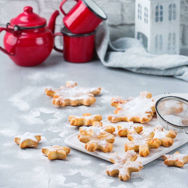 食べ物や飲み物、休日の概念。居心地の良いキッチン テーブルに自家製のクリスマス雪の結晶クッキー - 写真・画像