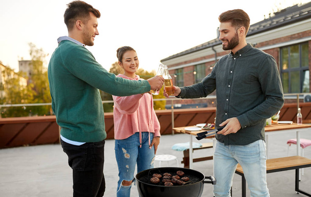 friends toast drinks at barbecue party on rooftop - Photo, image