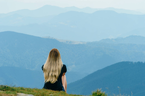 back view of blonde woman in beautiful carpathian mountains on summer day - Photo, Image