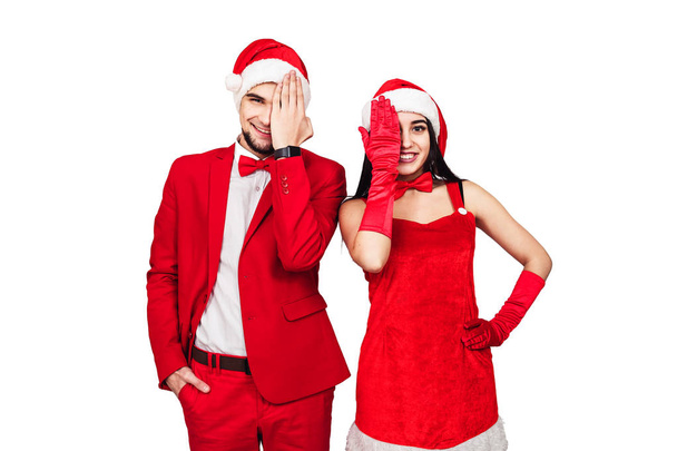 クリスマス テーマ パーティーでの楽しみを持っている若いカップル。サンタの帽子と赤いスーツ姿の若い男女 - 写真・画像