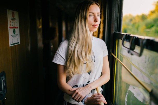 young woman with long hair travelling by train alone - Foto, imagen