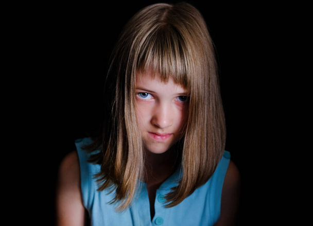 Portrait of a little girl with a shrewd look, black background - Фото, зображення