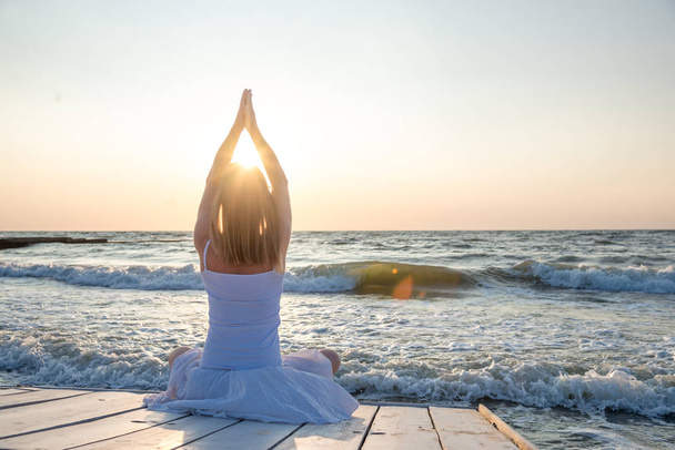 безмятежность и йога практикующие на море. восход солнца - Фото, изображение