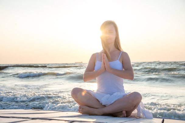 sereniteit en yoga beoefenen op zee. zonsopgang - Foto, afbeelding