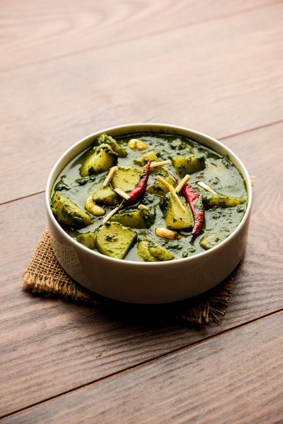 Aloo Palak sabzi ή Spinach Πατάτες κάρυ σερβίρεται σε ένα μπολ. Δημοφιλής ινδική υγιεινή συνταγή. Επιλεκτική εστίαση - Φωτογραφία, εικόνα