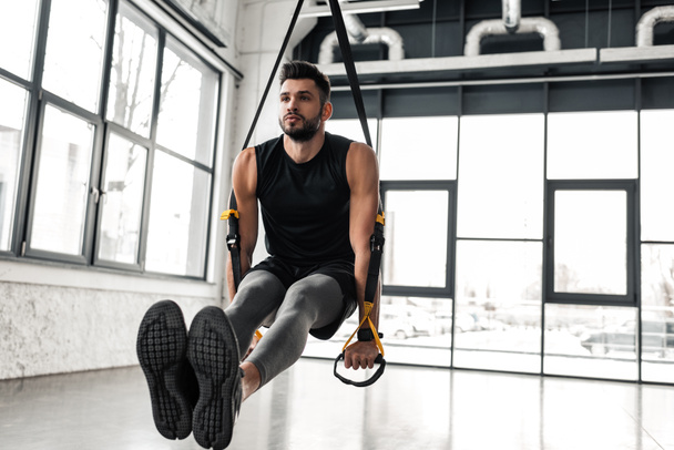 bonito muscular jovem desportista exercício com suspensão tiras no ginásio
 - Foto, Imagem